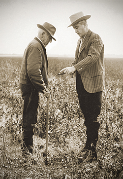A picture of Edward Mauldin speaking with a farmer.